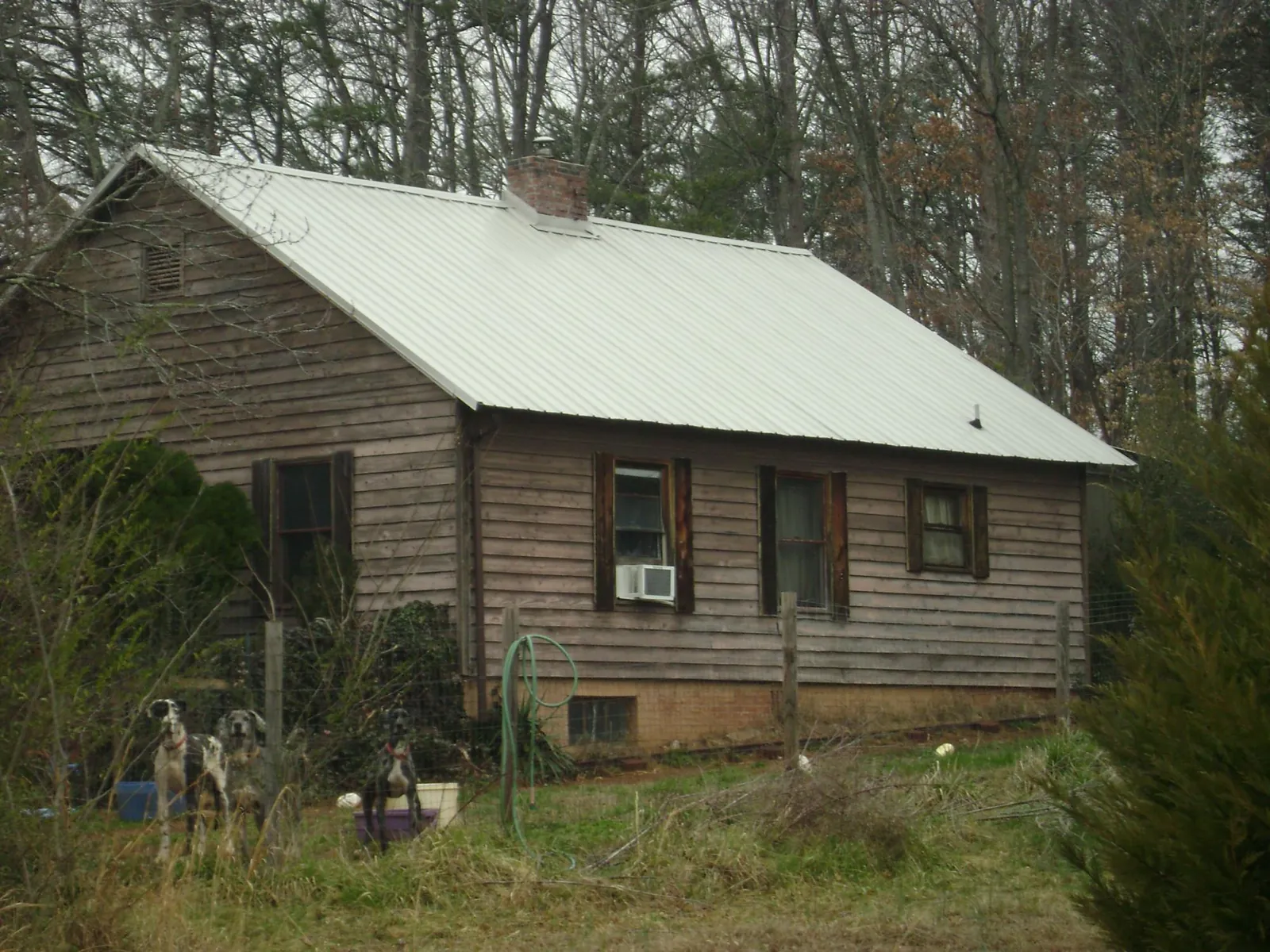 White metal roof on an old wood sided farmhouse, from a Metal Roof Installation job in Marquette